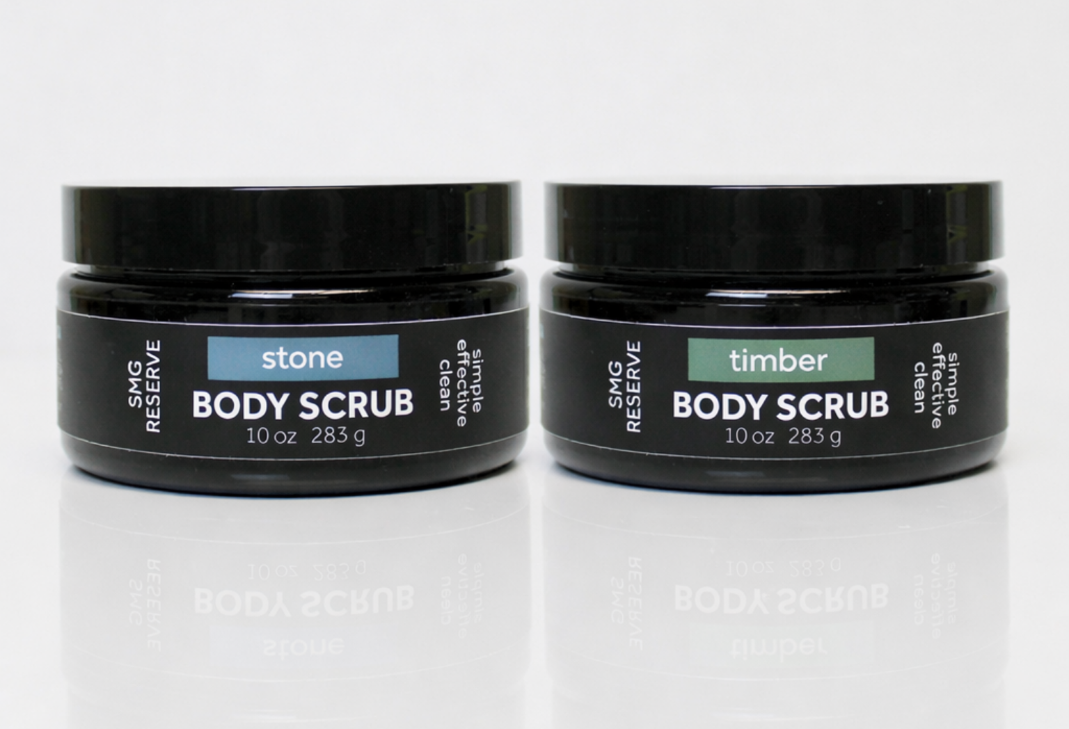 SMG Reserve exfoliating body scrub duo featuring Stone and Timber scents in black 10 oz jars on a white background